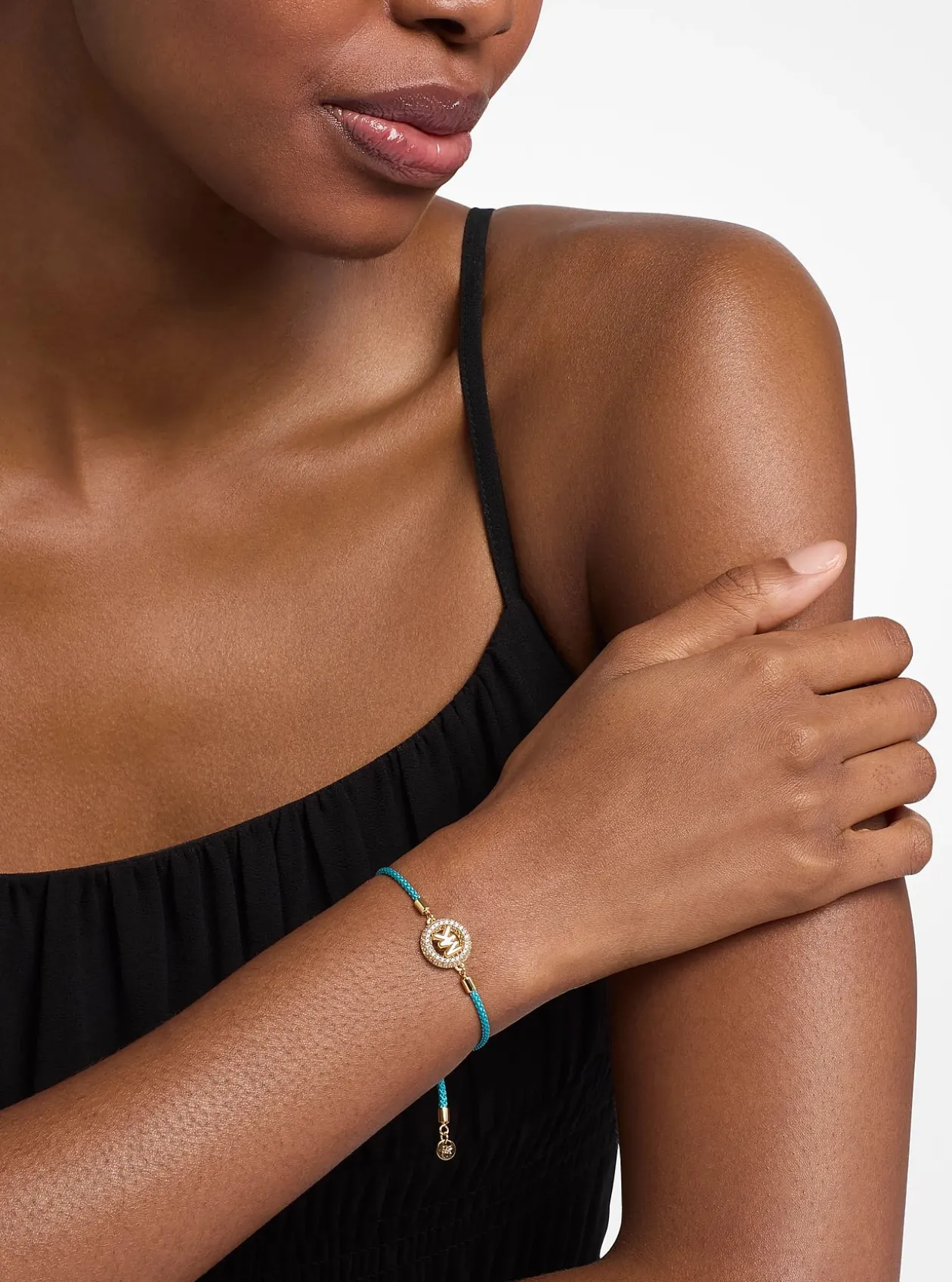 Bracelet en cordon avec logo doré à pierres pavées